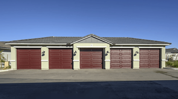 A building with a grey roof and red garage doors.